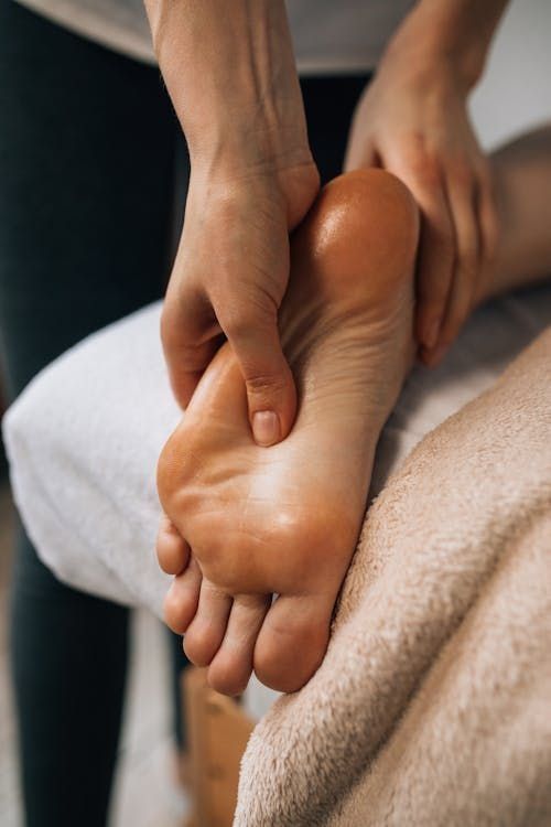 Therapist applying pressure during a foot reflexology treatment